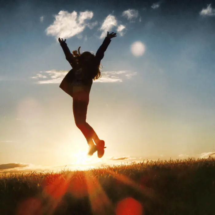 Silhouetted person jumping at sunrise, representing recovery and hope during medical detox