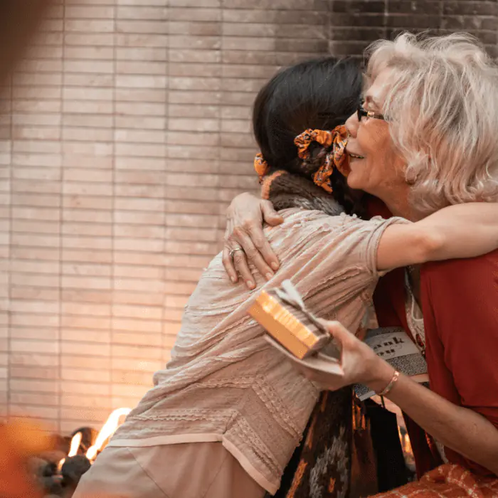 Older woman embracing younger woman in supportive hug addressing detox stigma