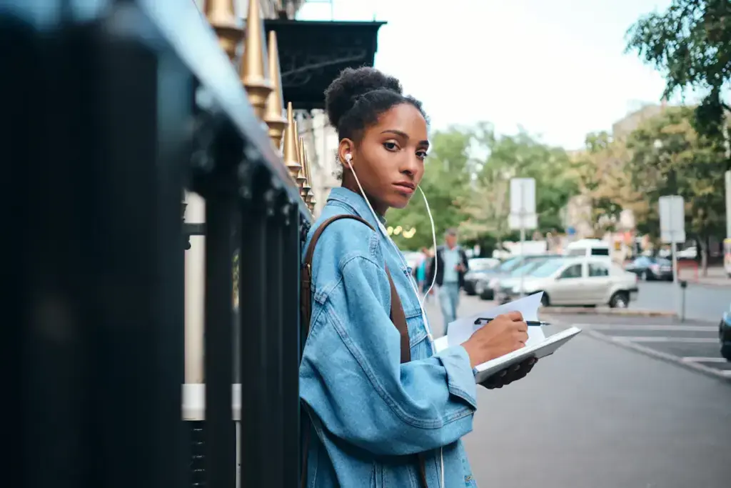 woman writes in notebook on city street 2026 09 22 18 33 28 utc