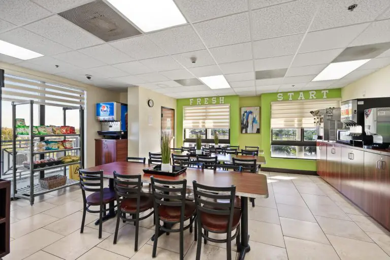 Communal dining area at Florida Helps recovery residence with tables and beverage station
